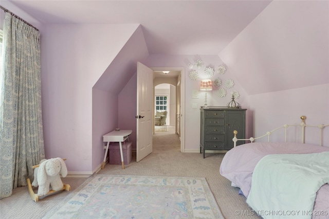 bedroom featuring light colored carpet and lofted ceiling