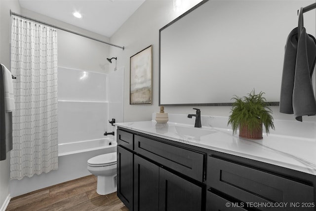 full bathroom featuring vanity, toilet, hardwood / wood-style floors, and shower / bath combo with shower curtain