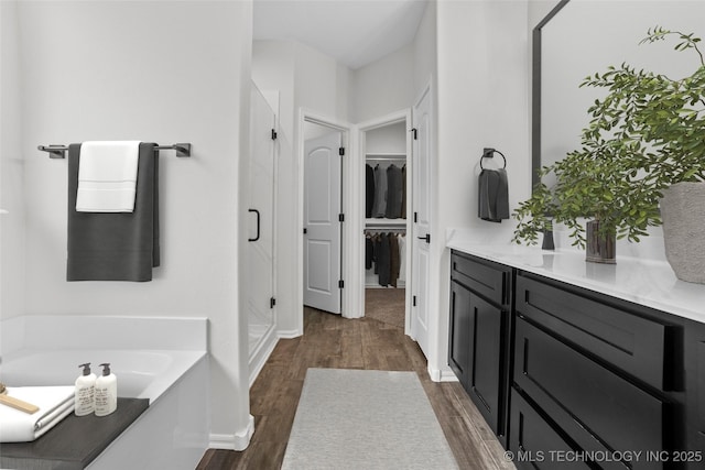 bathroom featuring vanity, a bath, and hardwood / wood-style floors