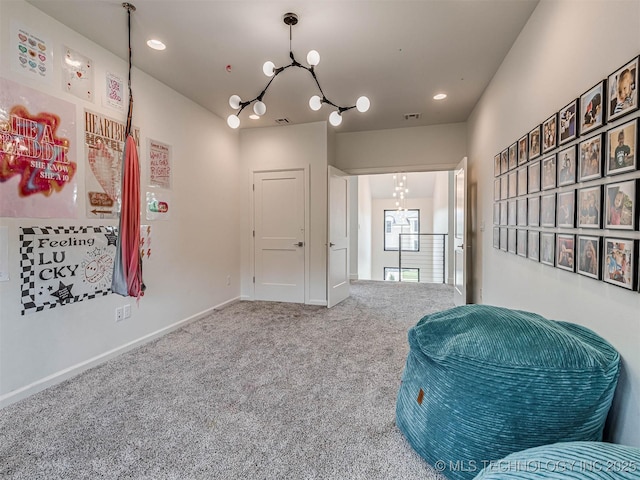 living area with carpet flooring and an inviting chandelier