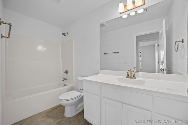 full bathroom featuring toilet, vanity, hardwood / wood-style flooring, and bathing tub / shower combination