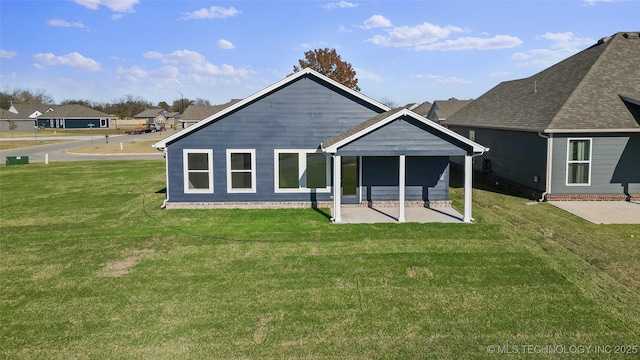 back of property featuring a patio and a lawn