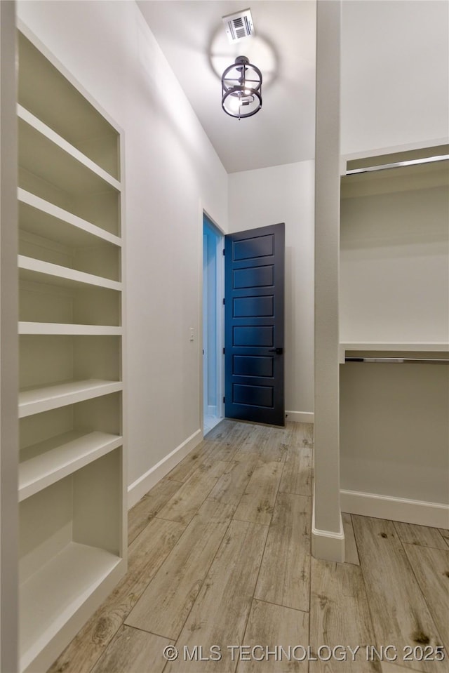 walk in closet with light wood-type flooring