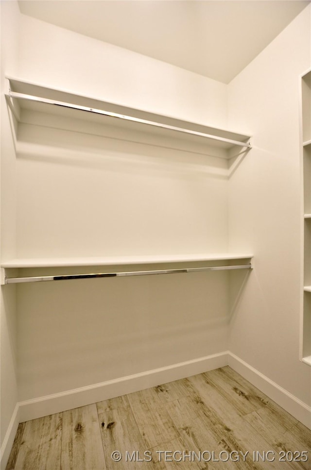 walk in closet with wood-type flooring