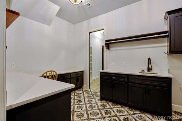 kitchen featuring dark brown cabinetry and sink