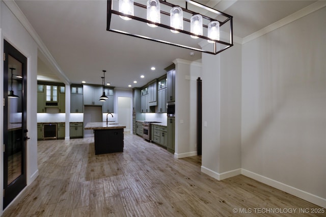 kitchen with light wood-type flooring, a center island, and ornamental molding