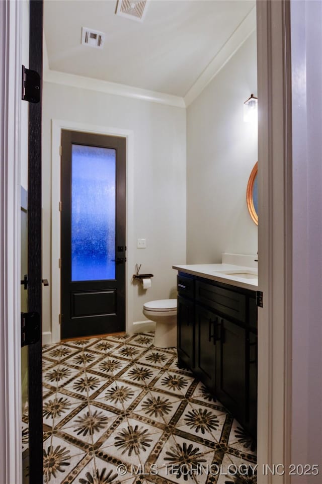 bathroom featuring tile patterned floors, toilet, vanity, and ornamental molding