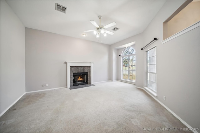 unfurnished living room featuring a tile fireplace, carpet floors, and ceiling fan