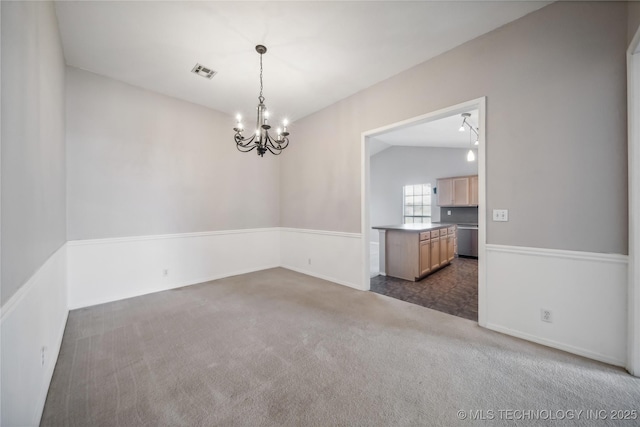 spare room with dark carpet, an inviting chandelier, rail lighting, and vaulted ceiling