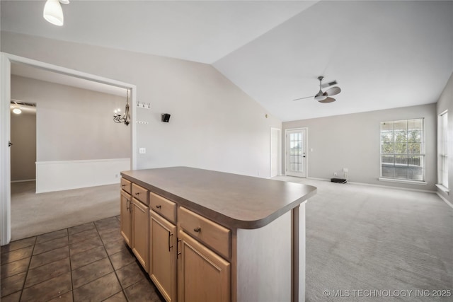 kitchen featuring ceiling fan, a kitchen island, lofted ceiling, and dark colored carpet