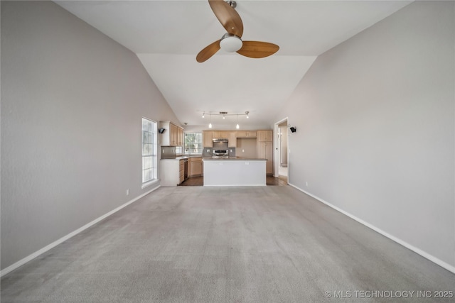 unfurnished living room featuring carpet flooring, ceiling fan, and vaulted ceiling