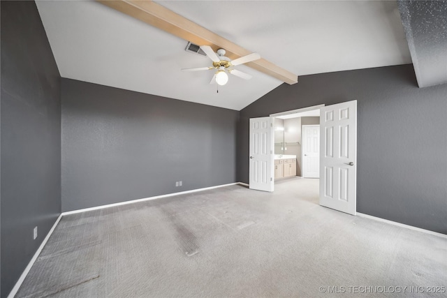 unfurnished bedroom featuring vaulted ceiling with beams, ceiling fan, ensuite bathroom, and carpet