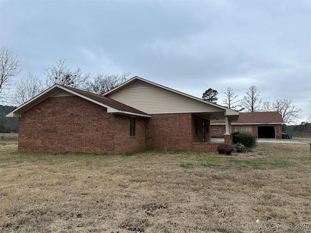 view of side of property featuring a lawn and a garage