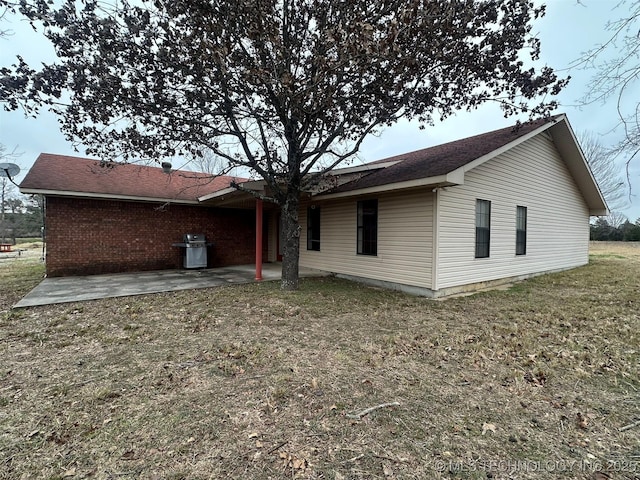 back of property featuring a patio area and a yard