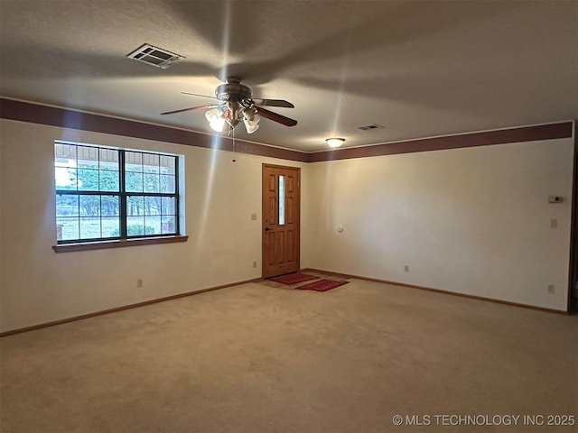 carpeted spare room featuring ceiling fan