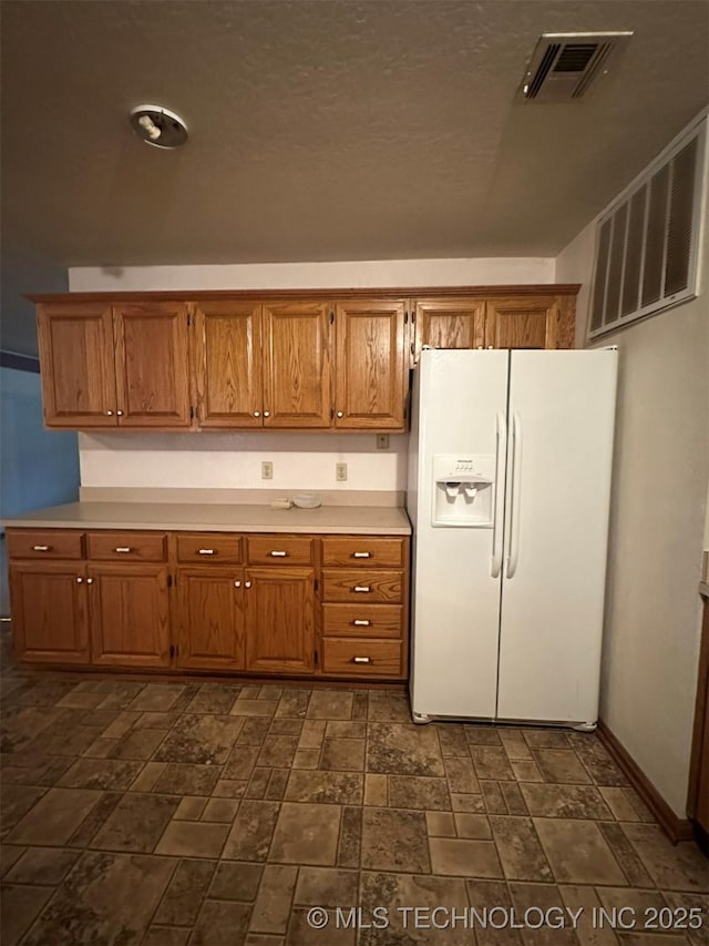 kitchen featuring white fridge with ice dispenser