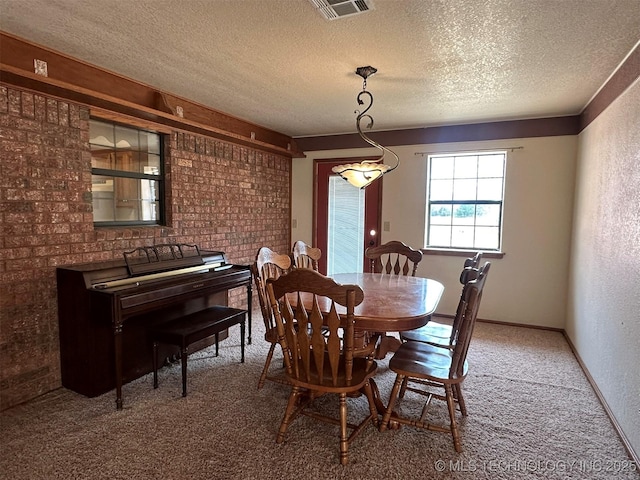 dining area featuring carpet and a textured ceiling