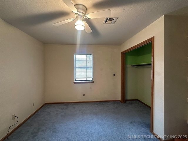 unfurnished bedroom with carpet flooring, a textured ceiling, a closet, and ceiling fan