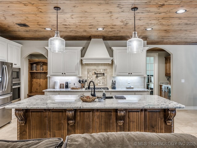 kitchen featuring white cabinetry, wooden ceiling, custom range hood, and a large island with sink