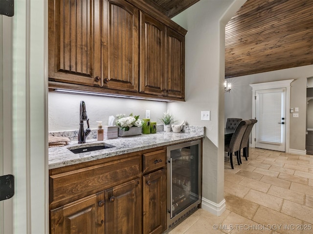 bar featuring lofted ceiling, sink, wine cooler, wood ceiling, and light stone countertops