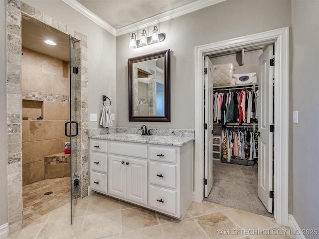 bathroom featuring vanity, crown molding, a walk in closet, and a stall shower