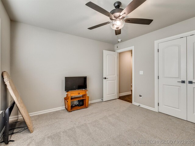 carpeted bedroom featuring ceiling fan and a closet