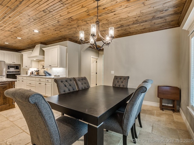 dining room with stone tile flooring, a chandelier, wood ceiling, and baseboards