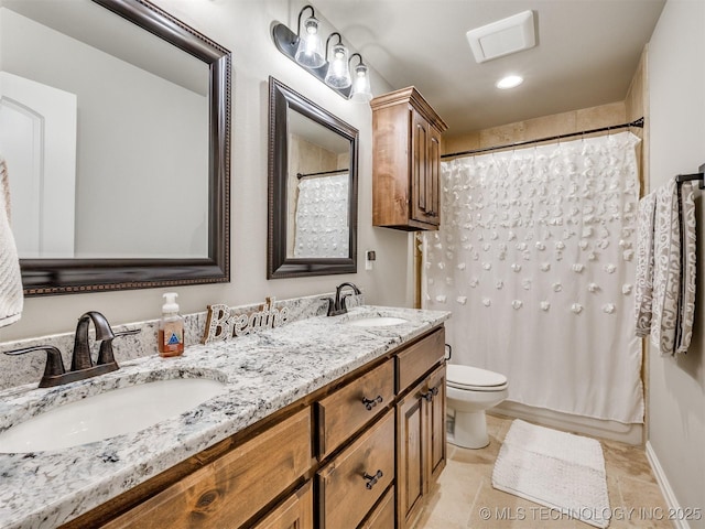 bathroom with double vanity, toilet, visible vents, and a sink