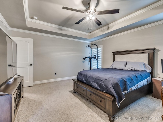 bedroom featuring a raised ceiling, ornamental molding, light colored carpet, and ceiling fan