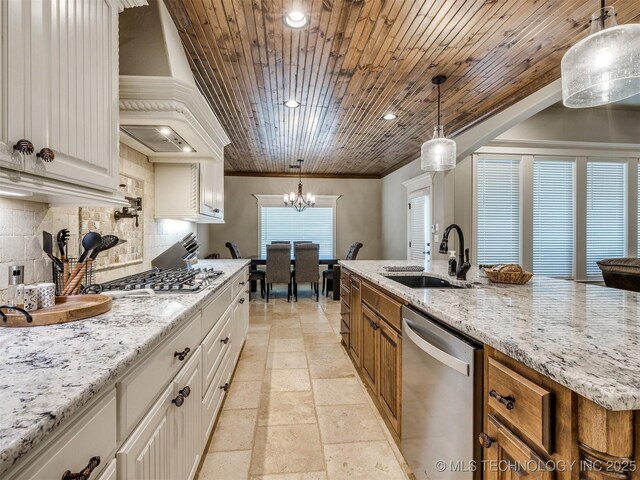 kitchen featuring custom exhaust hood, white cabinetry, hanging light fixtures, stainless steel appliances, and decorative backsplash