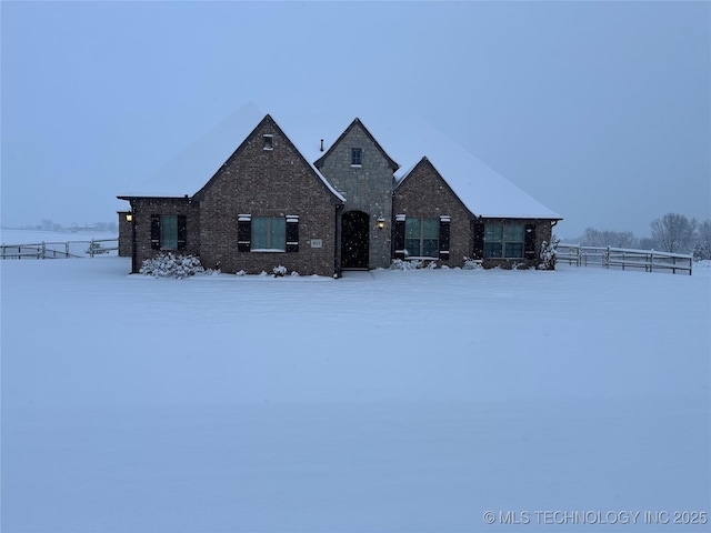 view of front of house with brick siding and fence