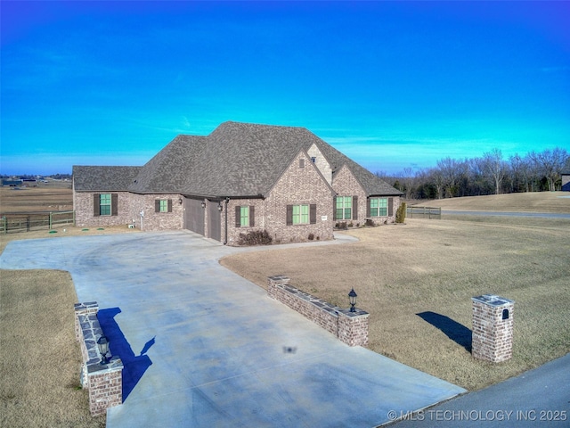 french country style house featuring fence, a shingled roof, concrete driveway, a garage, and brick siding