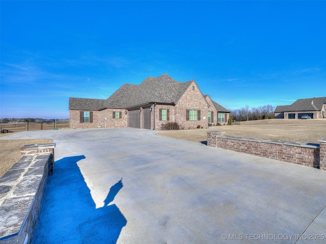 view of front of house with brick siding, a garage, and driveway