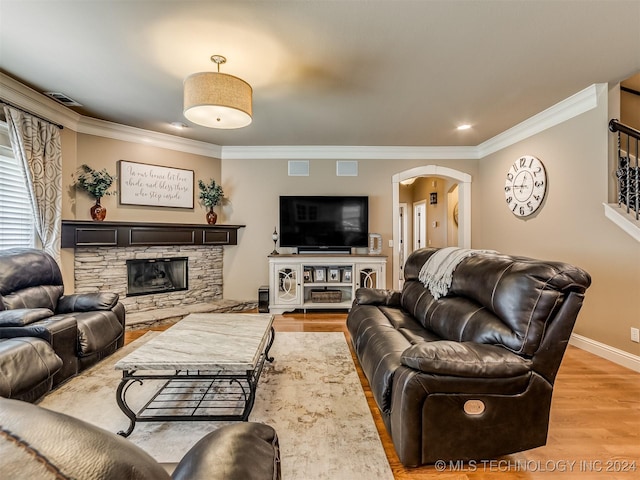 living room with crown molding, a fireplace, and hardwood / wood-style floors