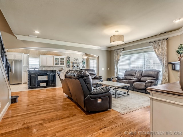 living room featuring ornamental molding and light wood-type flooring