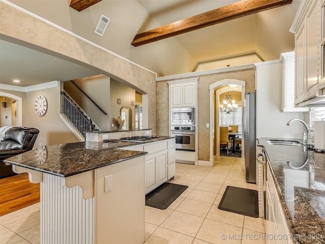 kitchen with stainless steel appliances, a kitchen bar, white cabinetry, and a center island