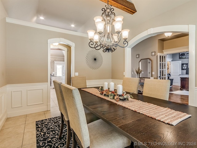 dining area featuring light tile patterned floors, beam ceiling, and a chandelier