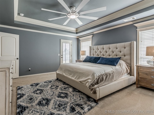 carpeted bedroom featuring ceiling fan, ornamental molding, and a raised ceiling