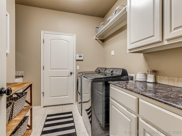 clothes washing area with cabinets, light tile patterned floors, and independent washer and dryer