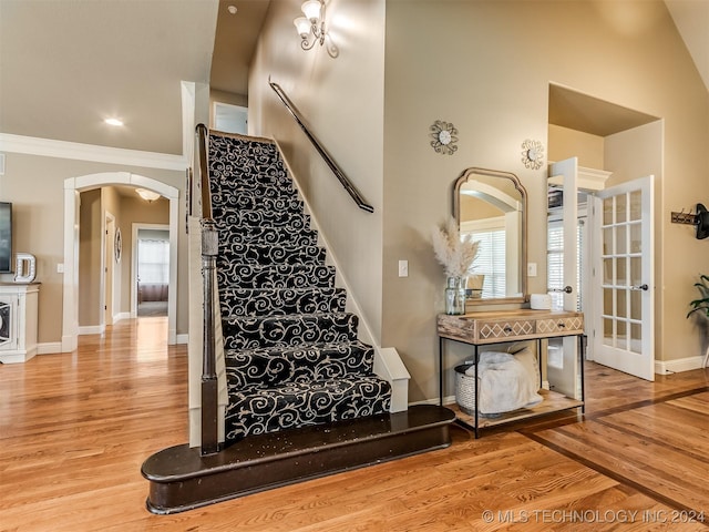 staircase featuring ornamental molding and hardwood / wood-style flooring