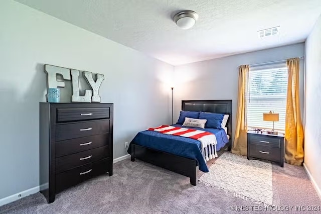 carpeted bedroom with a textured ceiling