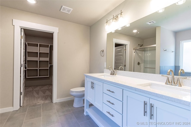 bathroom featuring tile patterned floors, vanity, toilet, and an enclosed shower