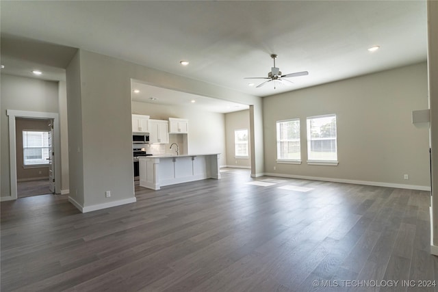 unfurnished living room with dark hardwood / wood-style flooring, ceiling fan, plenty of natural light, and sink