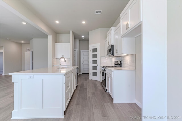 kitchen with white cabinetry, sink, a center island with sink, and appliances with stainless steel finishes