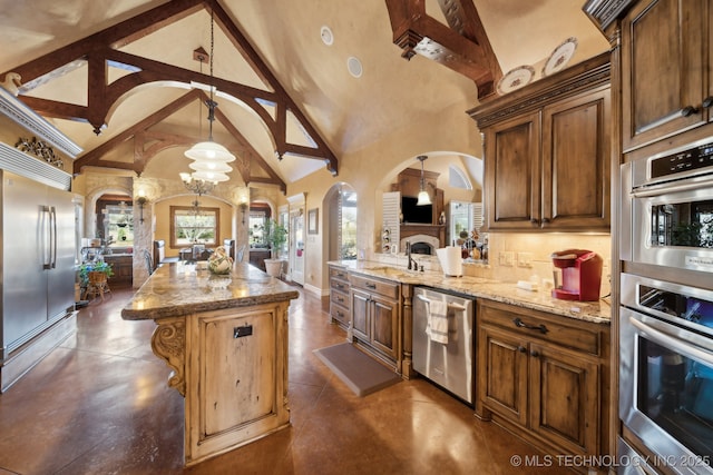 kitchen featuring light stone counters, stainless steel appliances, a center island, arched walkways, and high vaulted ceiling