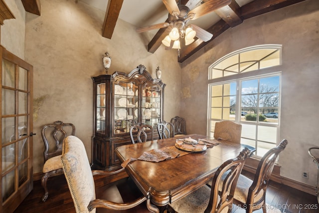 dining area with beamed ceiling, hardwood / wood-style floors, baseboards, a towering ceiling, and a ceiling fan