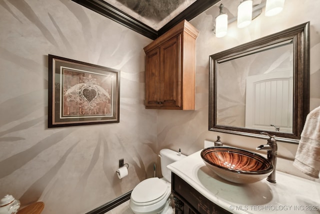 bathroom with toilet, crown molding, and vanity