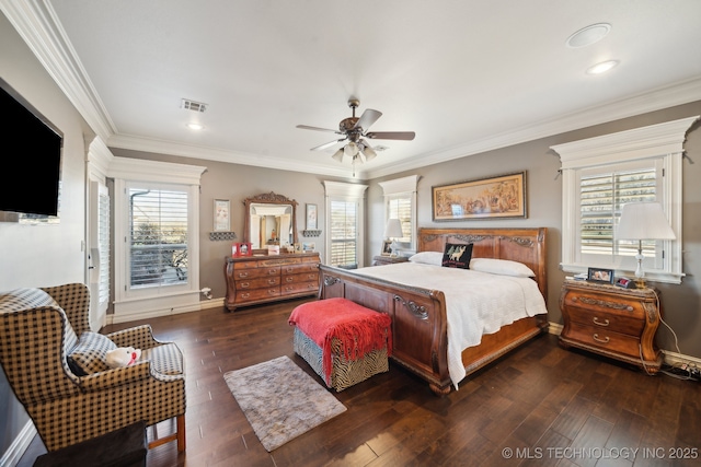 bedroom featuring crown molding, wood finished floors, ceiling fan, baseboards, and visible vents