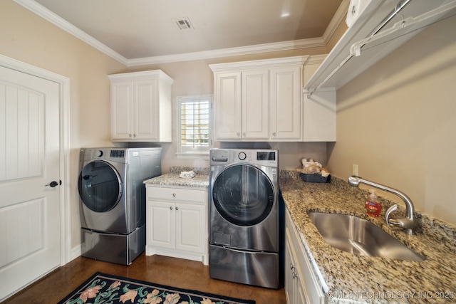 laundry area featuring a sink, cabinet space, washing machine and dryer, crown molding, and visible vents