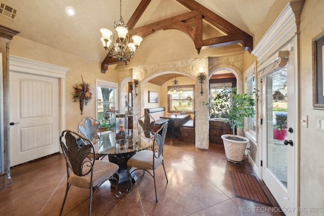 dining area with visible vents, arched walkways, dark tile patterned flooring, lofted ceiling with beams, and an inviting chandelier